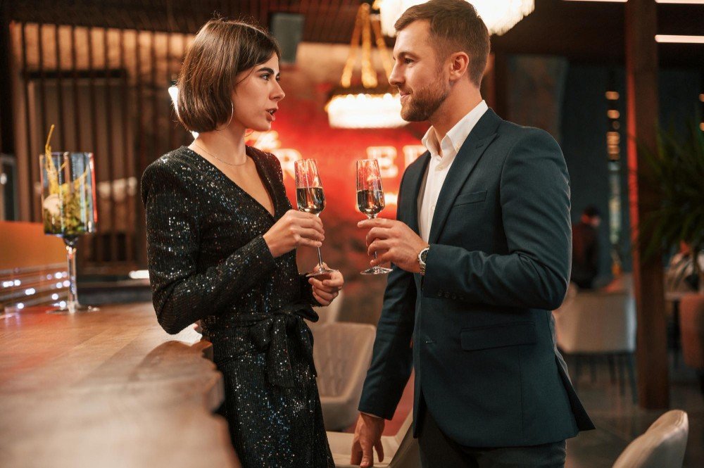 Adult sugar daddy and sugar baby talking in a staffed public venue